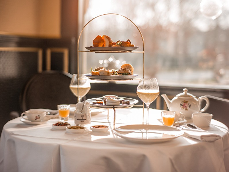 High Tea op een sfeervol gedekte tafel bij Amrâth Berghotel Amersfoort, met etagère vol hartige en zoete hapjes.