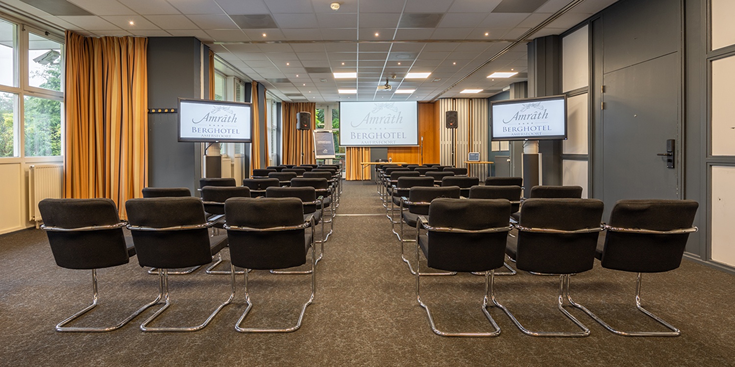 Vergaderruimte in Amrâth Berghotel Amersfoort met comfortabele zwarte stoelen met veel daglicht