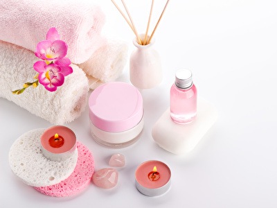 Diverse spa-producten zoals oliën en zepen op een witte achtergrond.